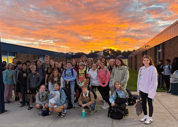 large group of 7th graders with the sunrise in the background 