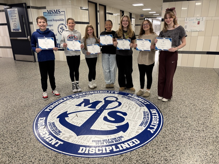 students of the month in the lobby with their certificates