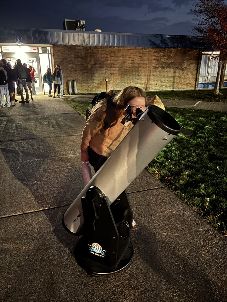 student looking through telescope