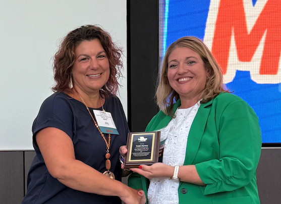 Two females holding a plaque