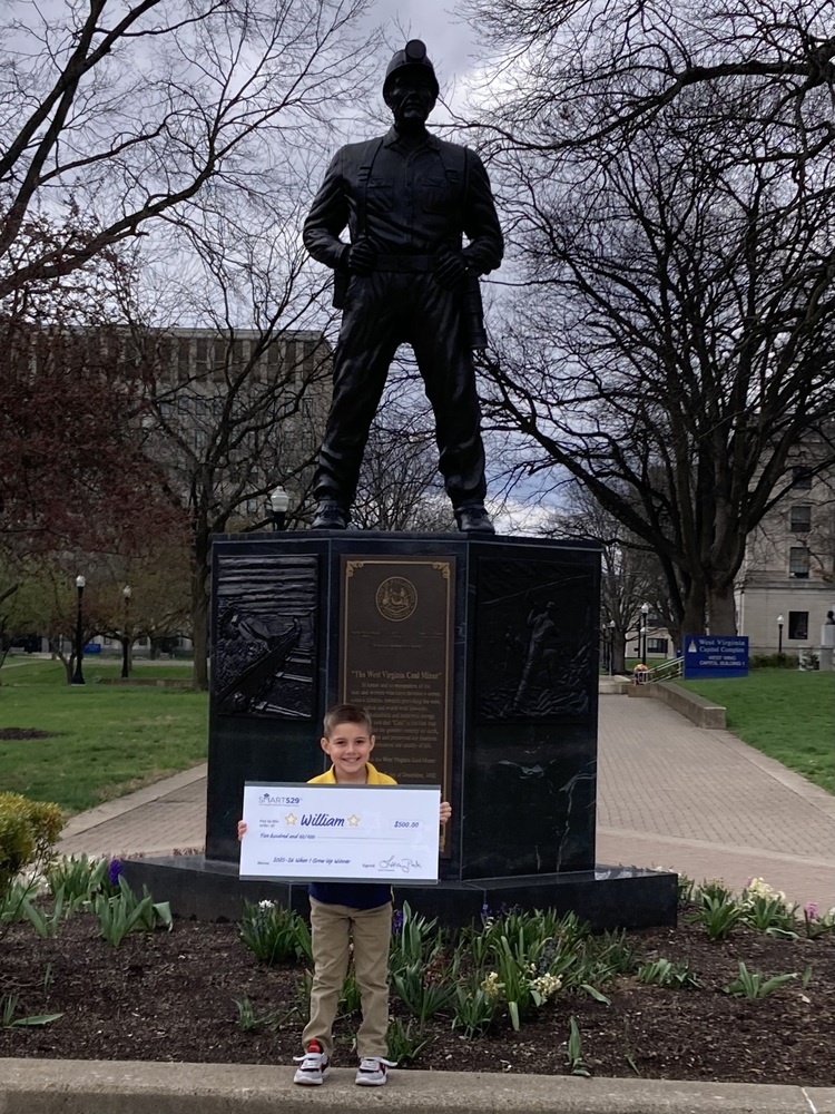 Knidergaren writing contest winner displaying check