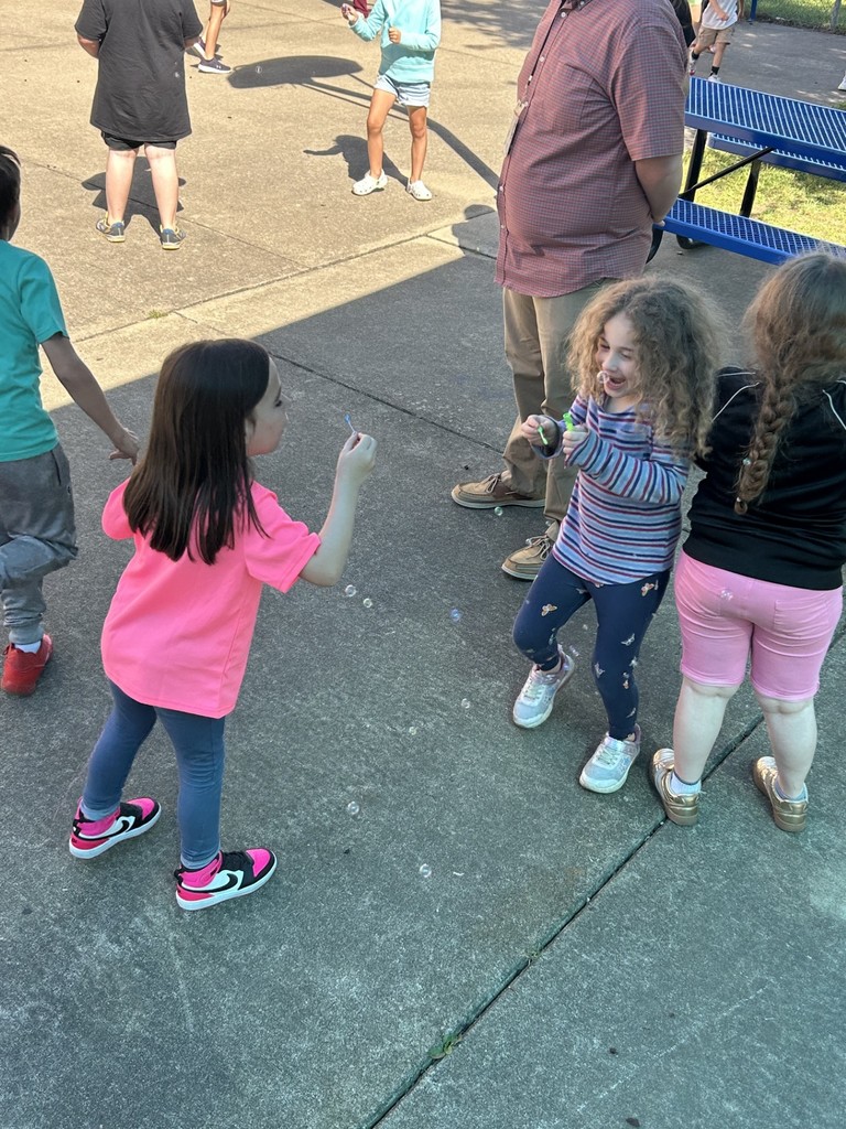 Students enjoying an outside dance party and bubble blowing to celebrate perfect attendance