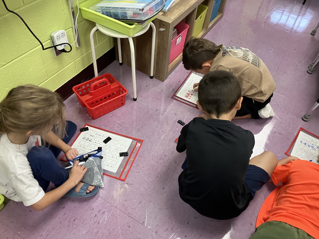 First graders engaged in math stations, building fluency with addition facts through hands-on activities and collaborative learning