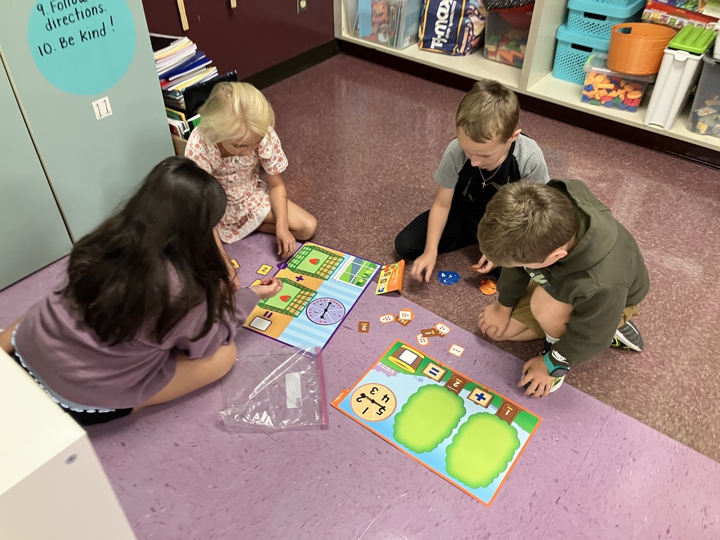 First graders engaged in math stations, building fluency with addition facts through hands-on activities and collaborative learning
