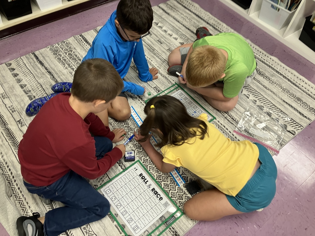 First graders engaged in math stations, building fluency with addition facts through hands-on activities and collaborative learning