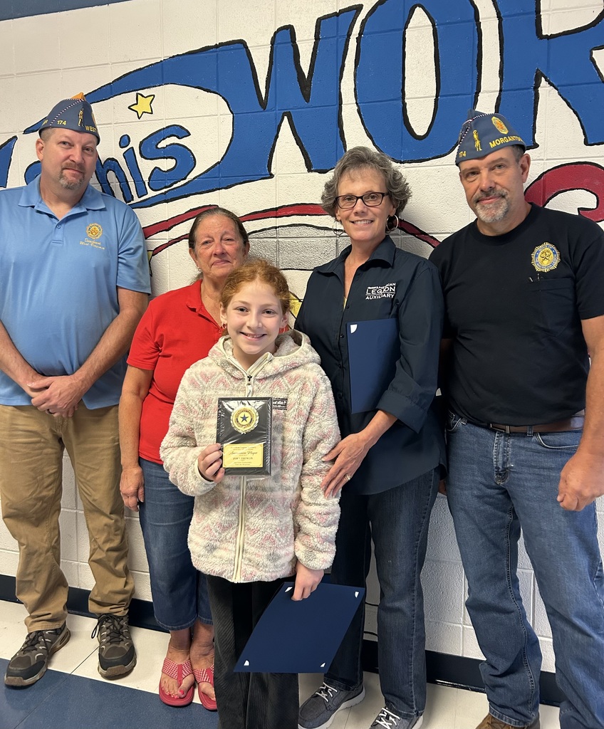 One student standing with Legion members  with her plaque