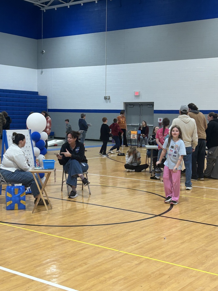 students and families mingling around the gym during harvest bash