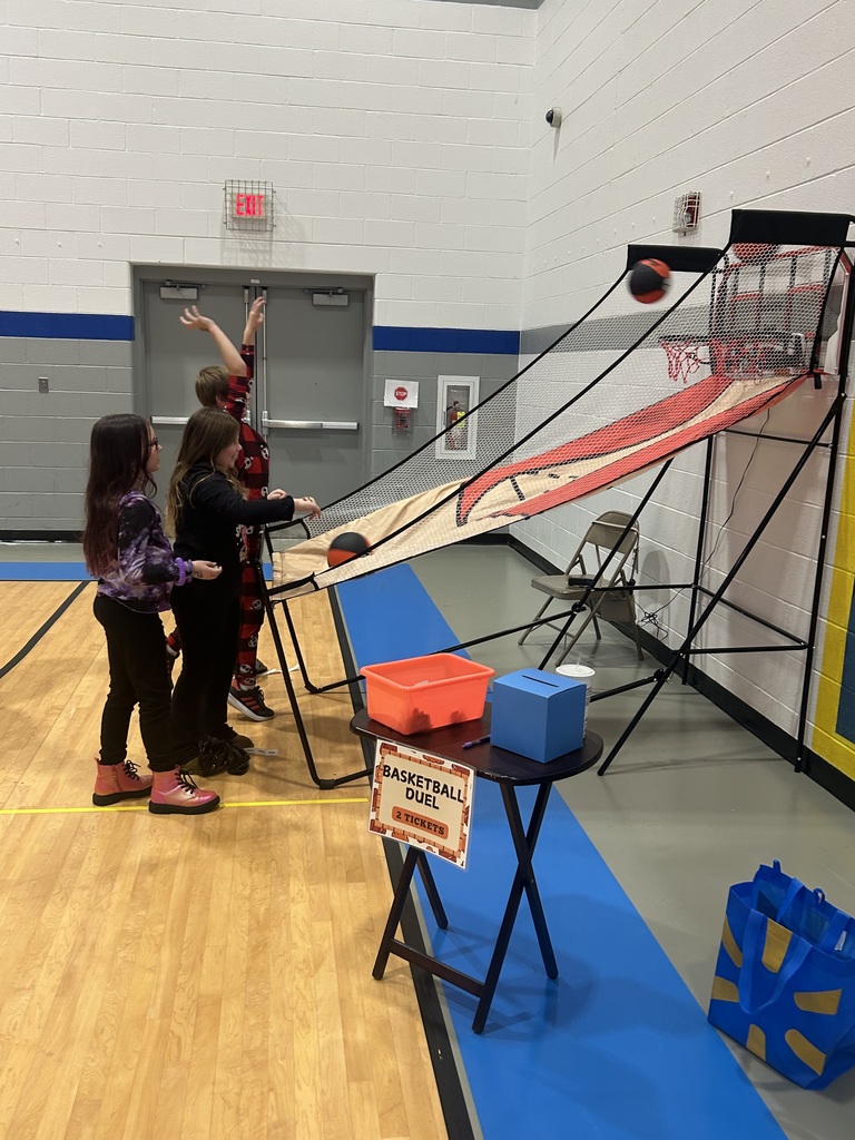 Three students shooting basketball at a station