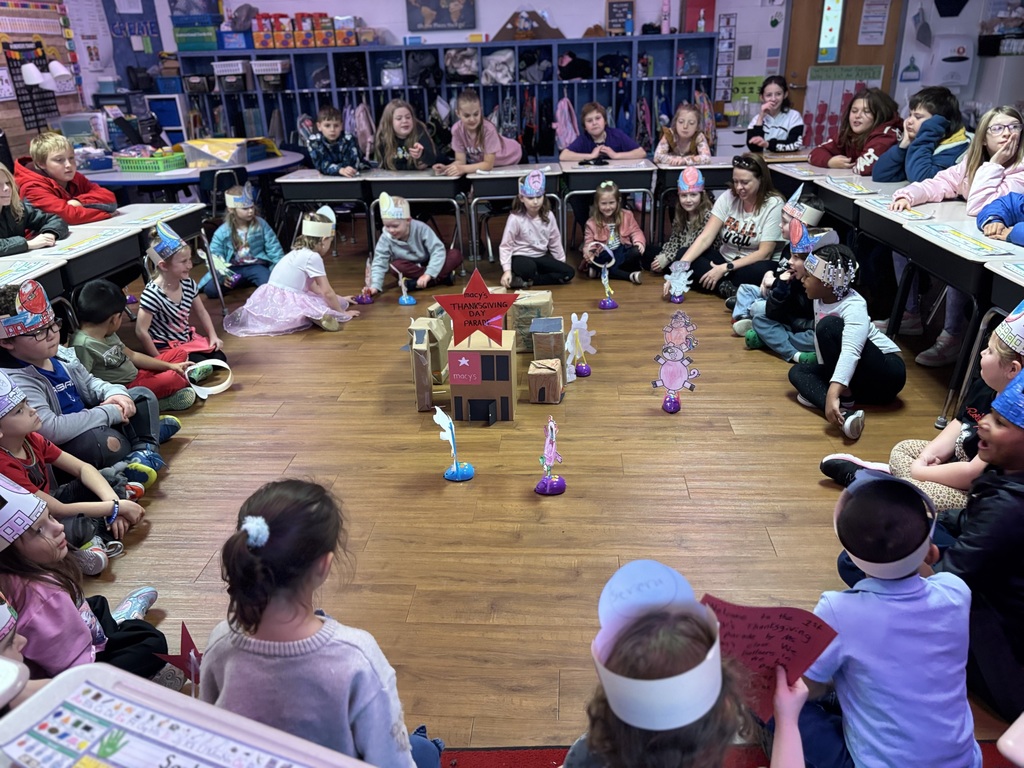 class of first graders gathered around a city made of boxes  watching their coding mice parade