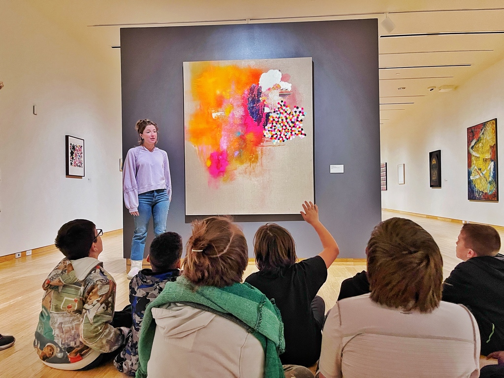 Woman speaking to a group of seated children