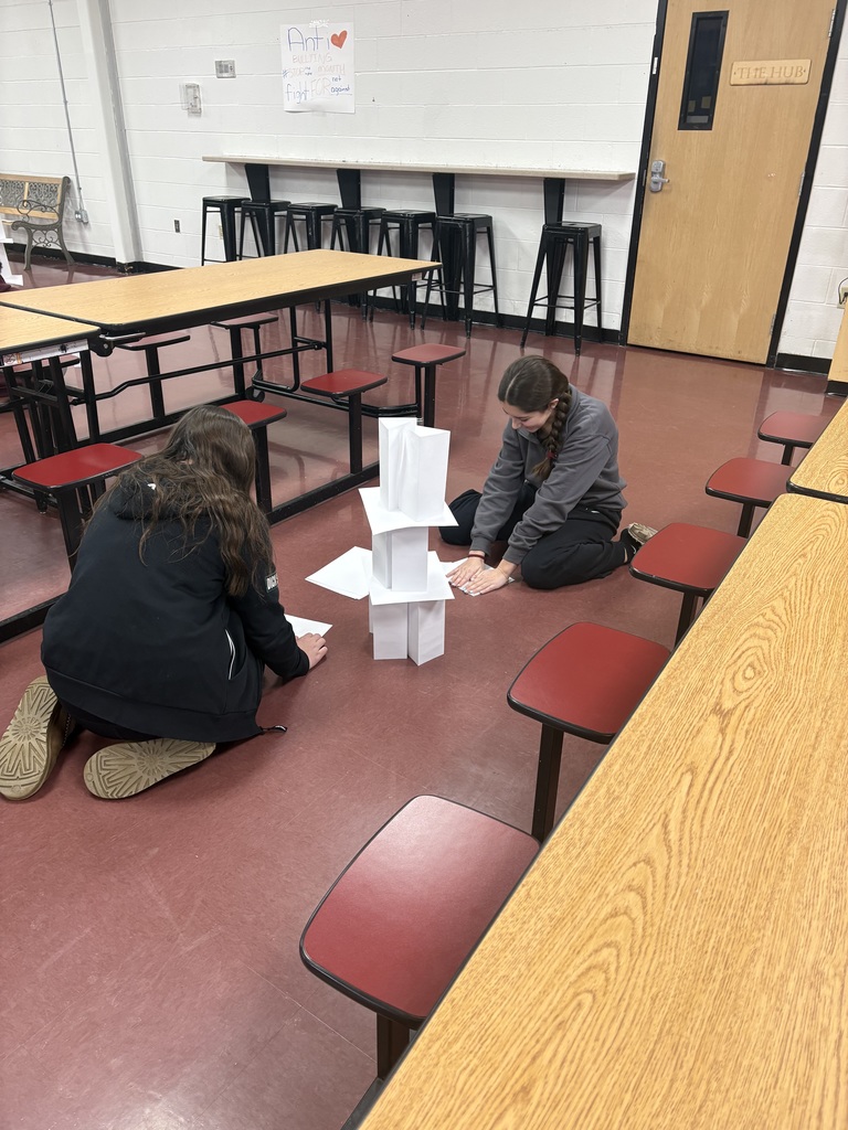 2 students building a paper tower