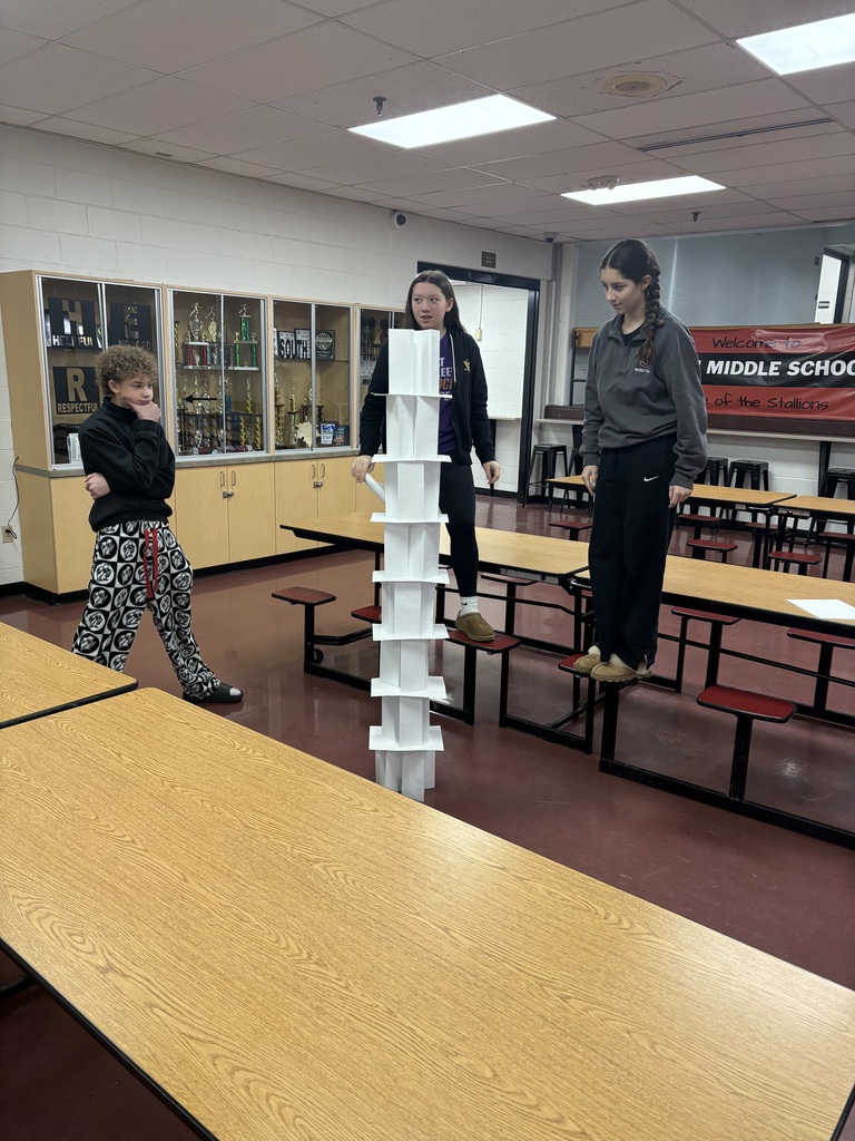 3 students with a paper tower