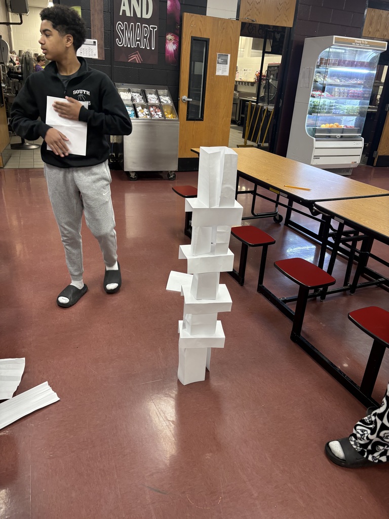 a student building a paper tower