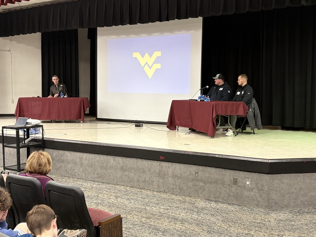 2 athletes sitting at a table being interviewed