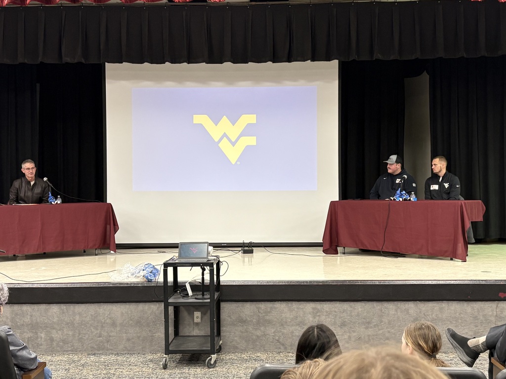 2 athletes sitting at a table being interviewed