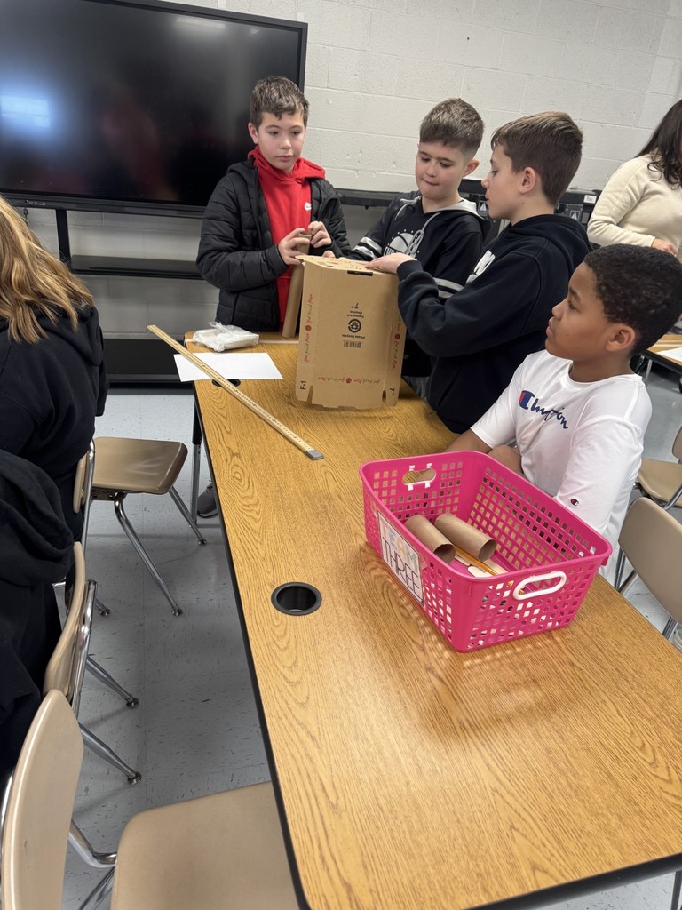 In the STEAM Lab making a sled run. Students had to design an incline that would allow their sled to complete the run and keep their snowman parts and people inside the sled. They measured the distance their sled ran.