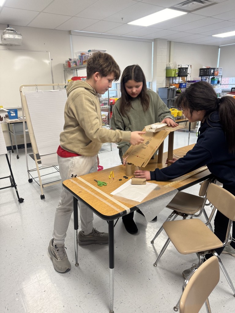 In the STEAM Lab making a sled run. Students had to design an incline that would allow their sled to complete the run and keep their snowman parts and people inside the sled. They measured the distance their sled ran.
