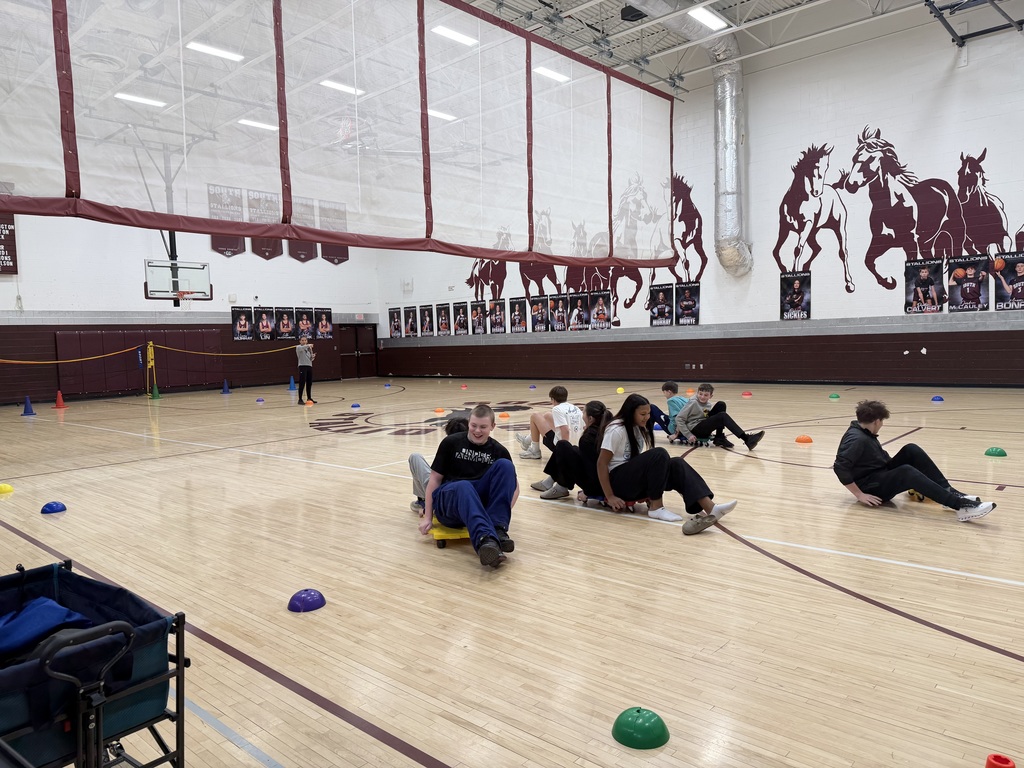 Students racing on scooters in the gym