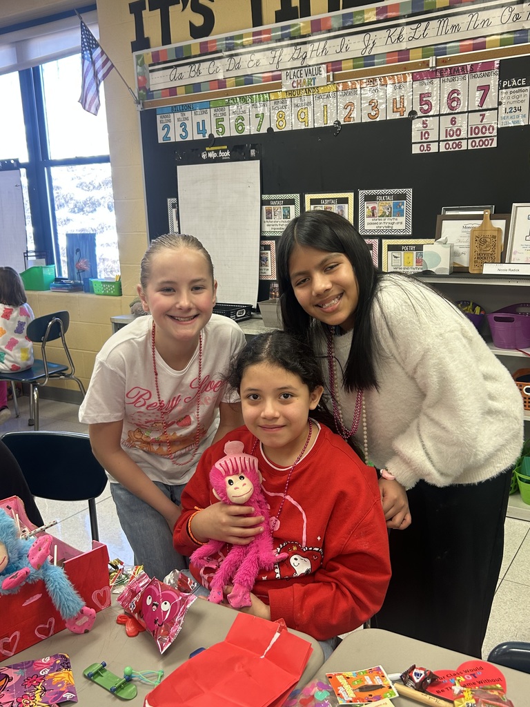 Three girls with a pink monkey posing with at valentines party