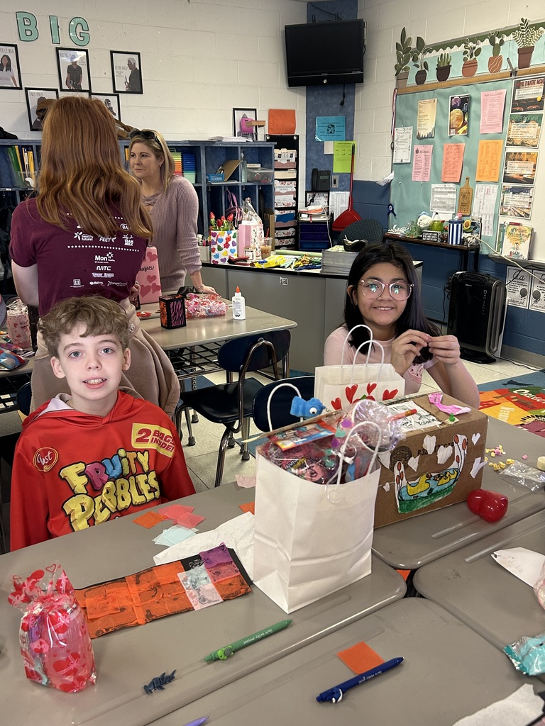 two students posing with valentines and candy