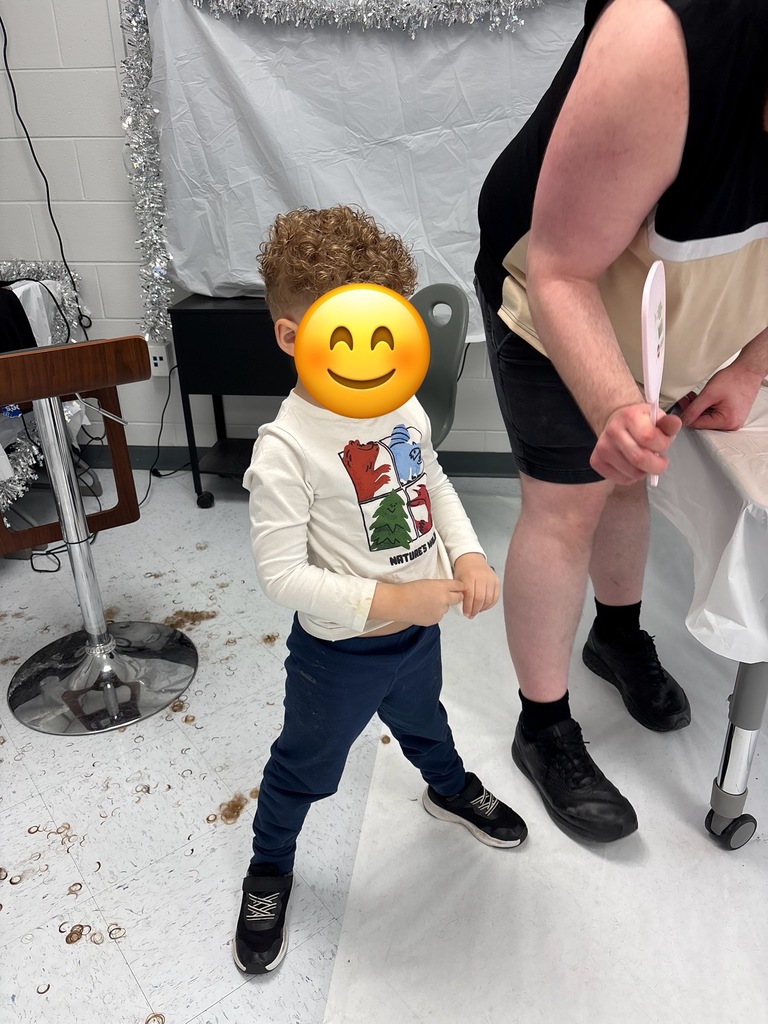 Picture shows students getting haircuts at school