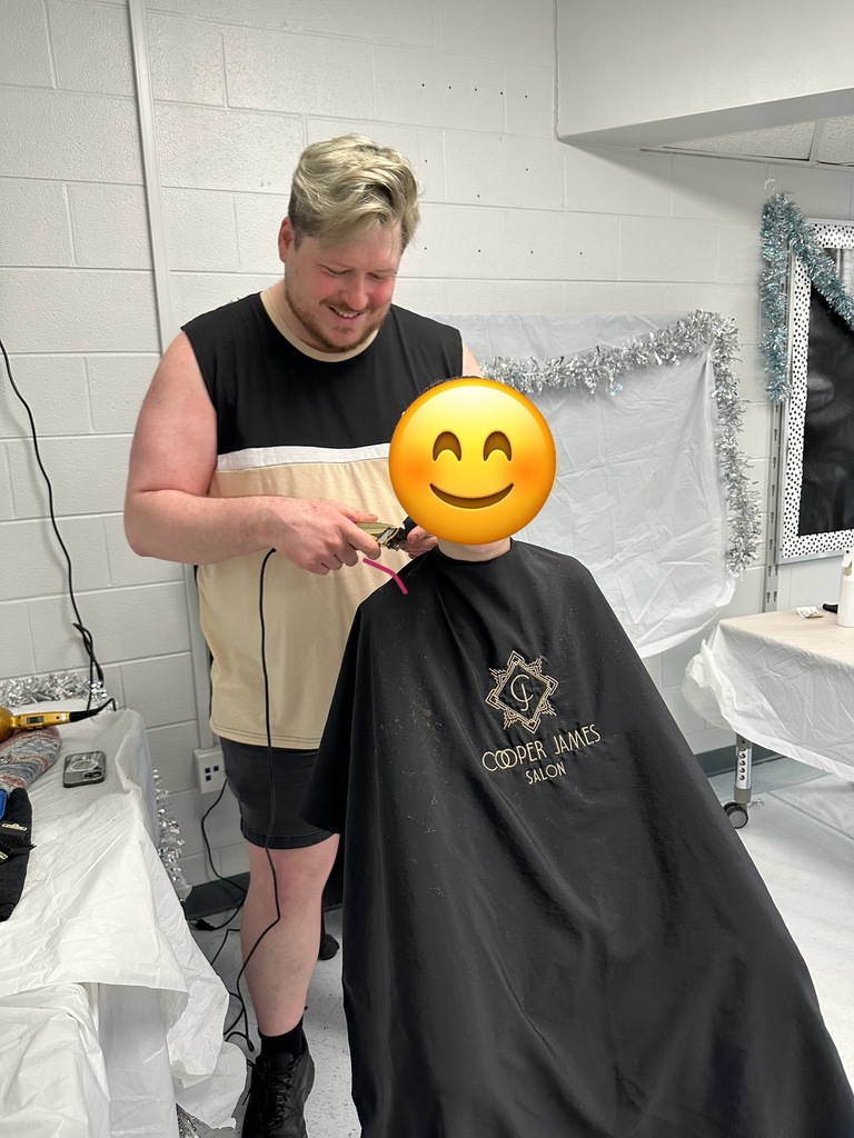 Picture shows students getting haircuts at school
