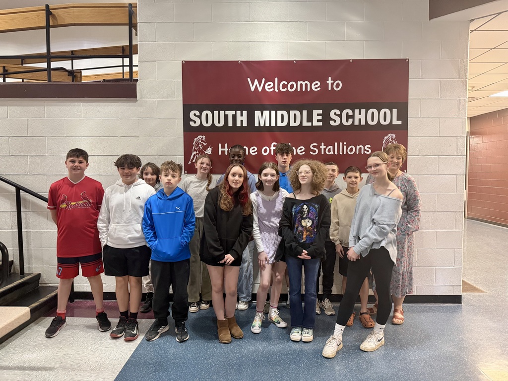 Students standing in front of our school banner