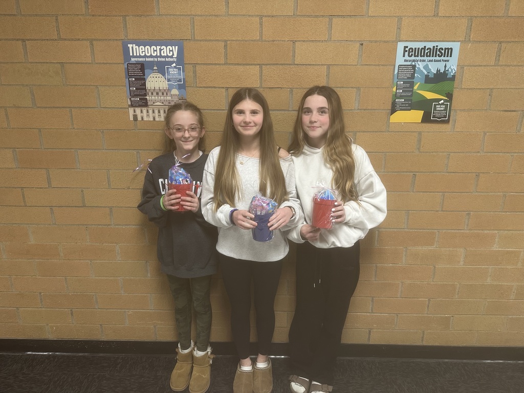 Students holding a winning cup with prizes in it