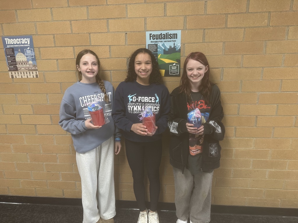Students holding a winning cup with prizes in it