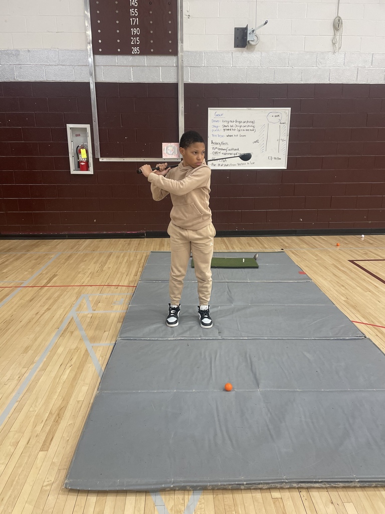 student swinging a golf club