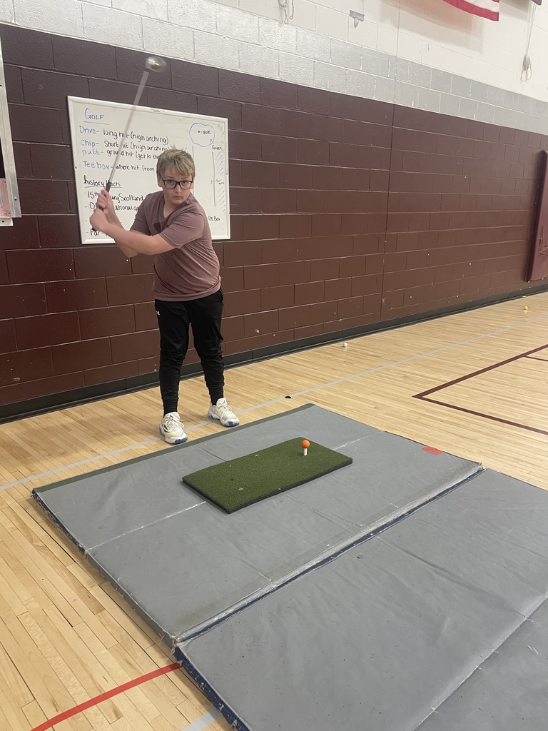 student swinging a golf club