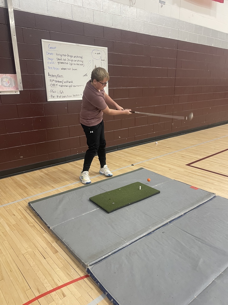 student swinging a golf club