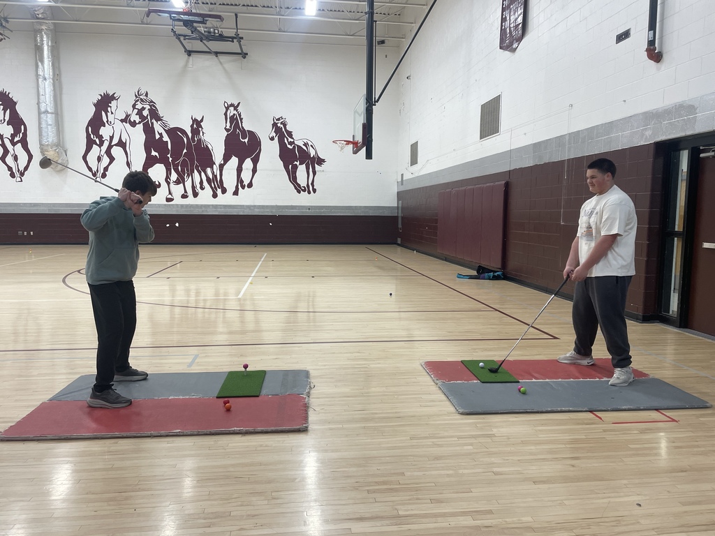student swinging a golf club