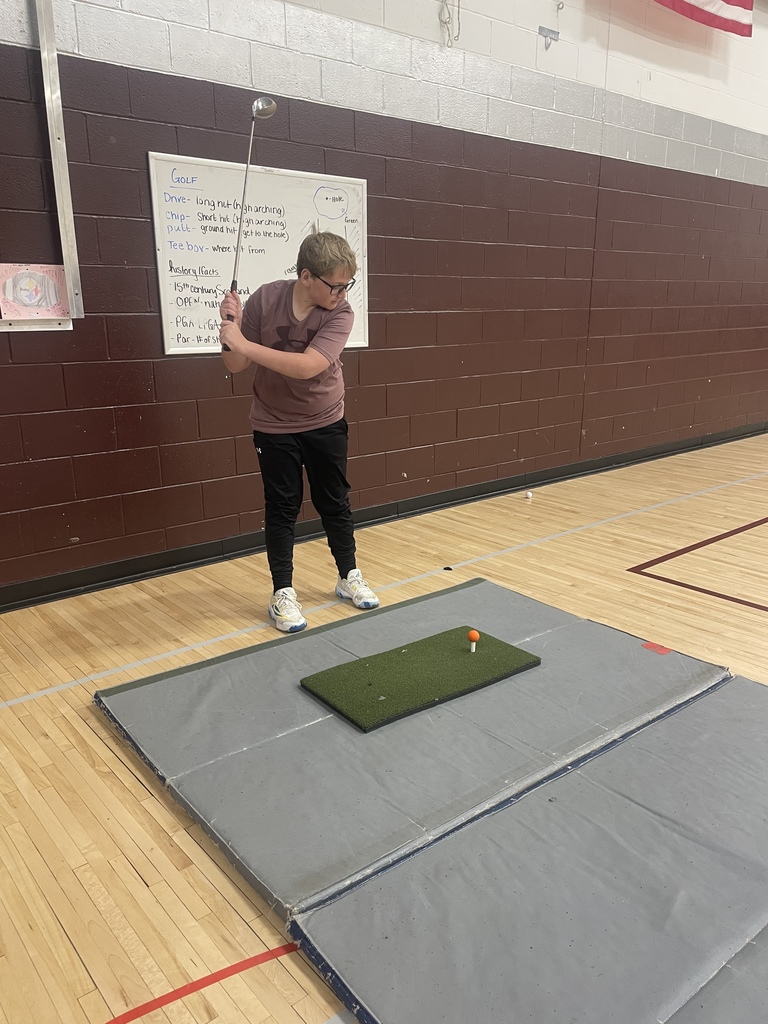 student swinging a golf club
