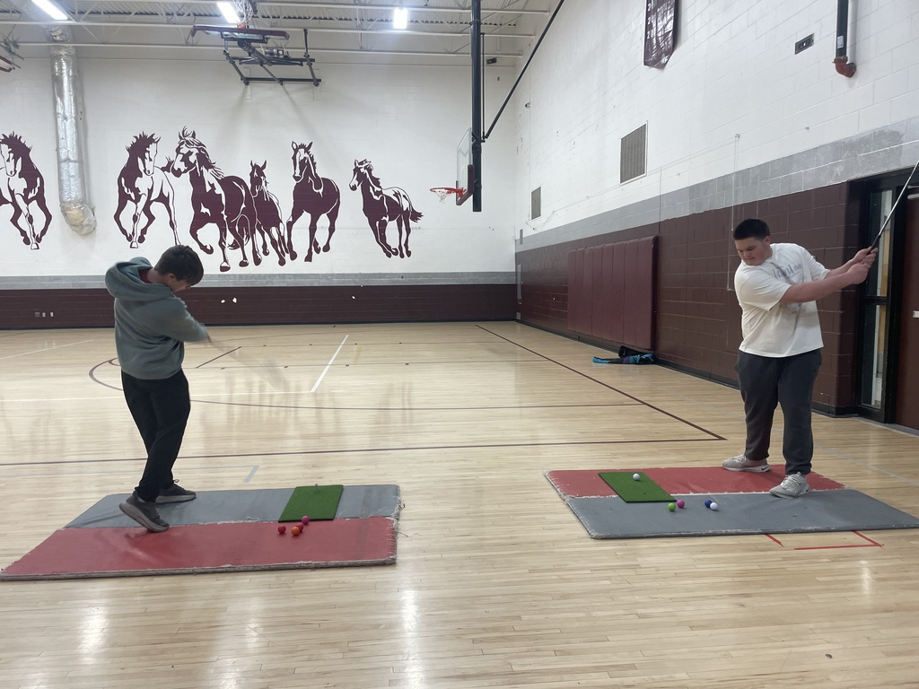 student swinging a golf club