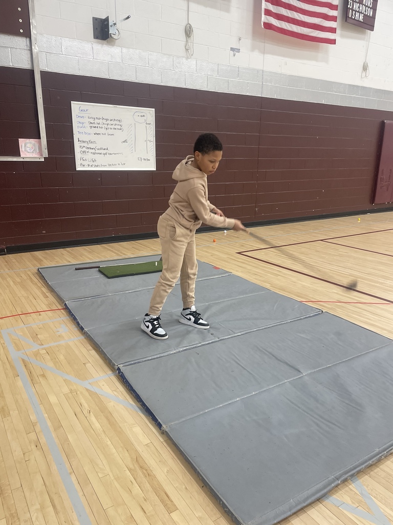 student swinging a golf club
