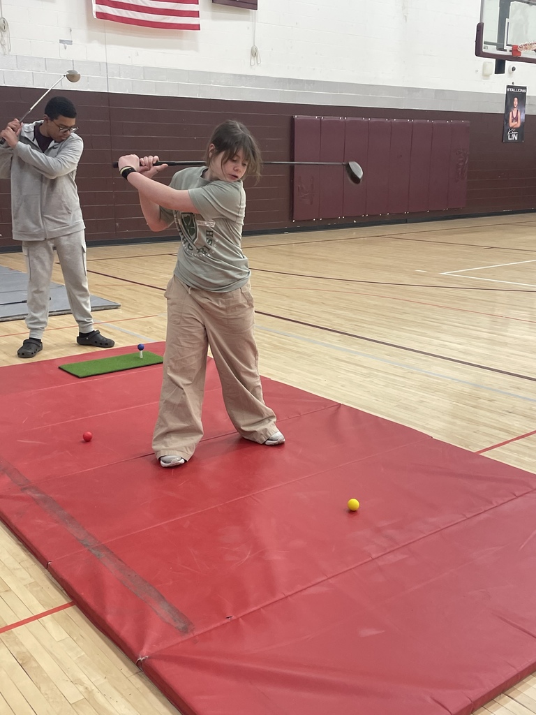 student swinging a golf club