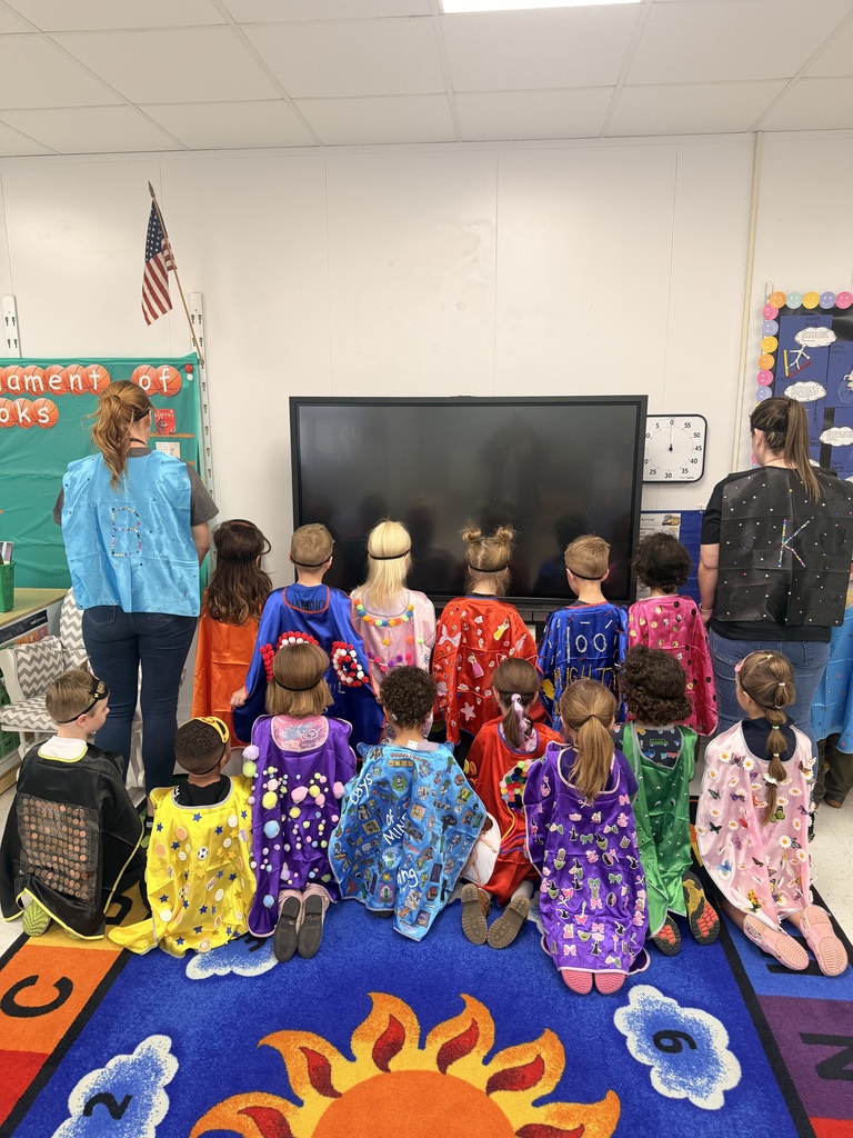 The back of Prek students dressed up as super heroes with 100 items on cape