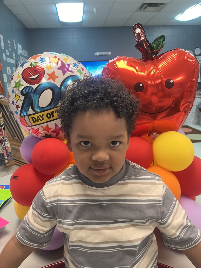 PreK student in front of balloons celebrating 100 days!