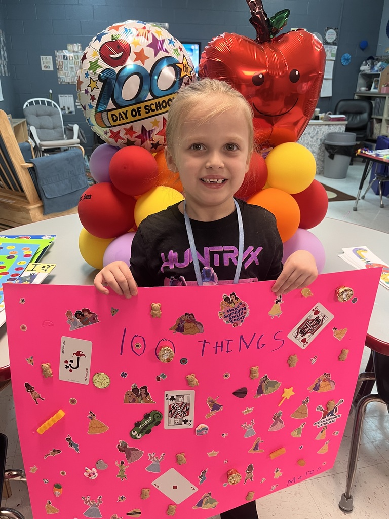 PreK student in front of balloons celebrating 100 days with a poster project!