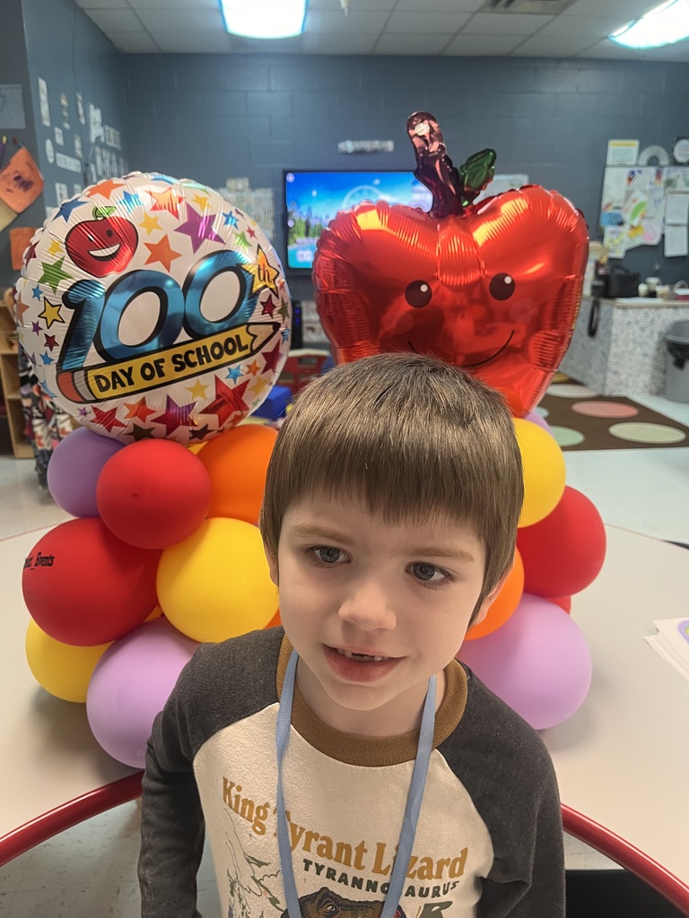 PreK student in front of balloons celebrating 100 days!