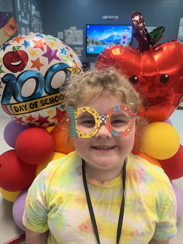 PreK student in front of balloons celebrating 100 days!