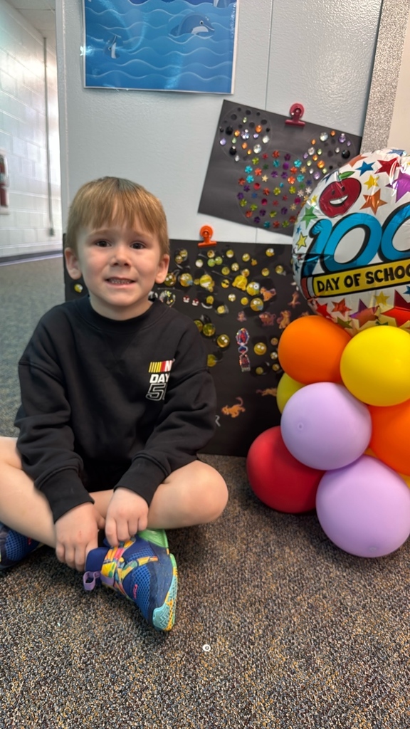 PreK student in front of balloons celebrating 100 days!