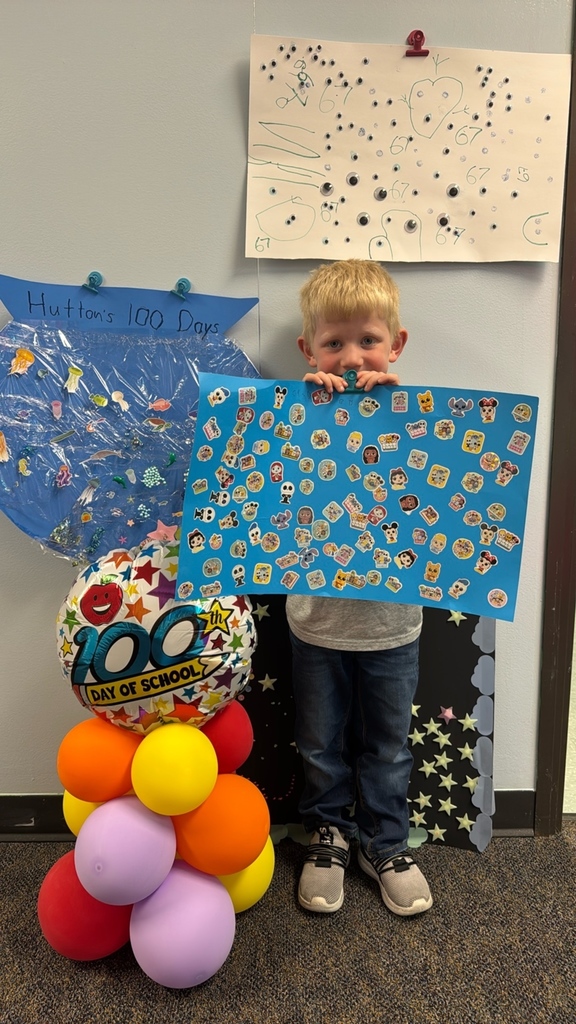PreK student in front of balloons celebrating 100 days with a poster project!