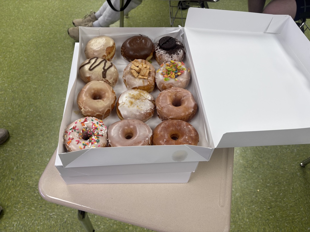 An open box containing a variety of 12 donuts