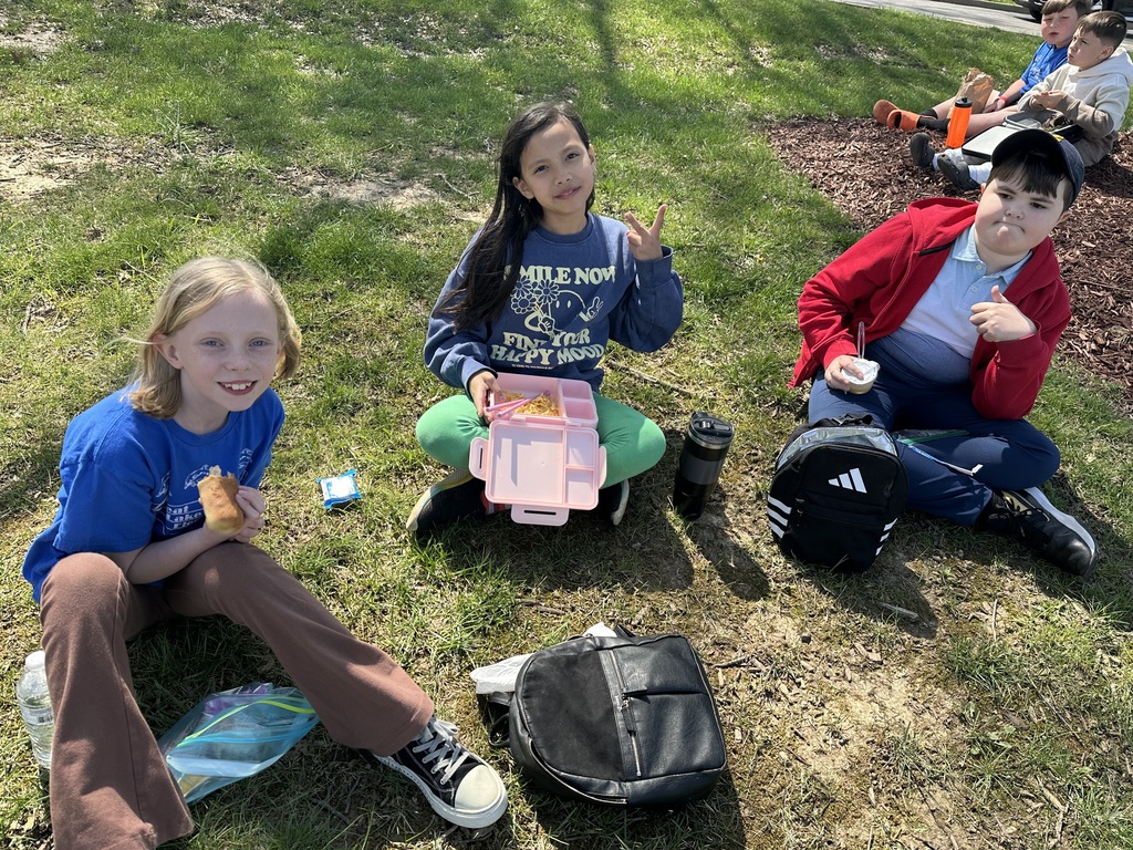 two girls and a boy eating lunch