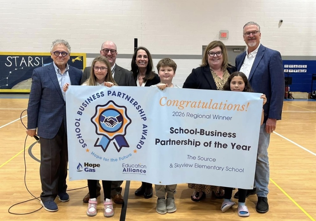 Superintendent Cambell and Talerico stand with 3 students along woth Ms. Cox and Kevin Cain from the Source holding a banner