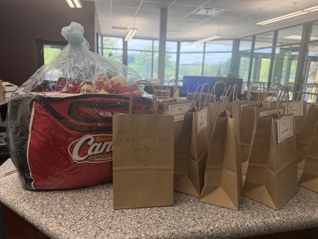 Cane's Gift Basket and various brown bags with gift card totals on them. They are sitting on a counter