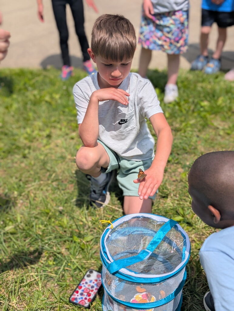 Student holding a butterfly