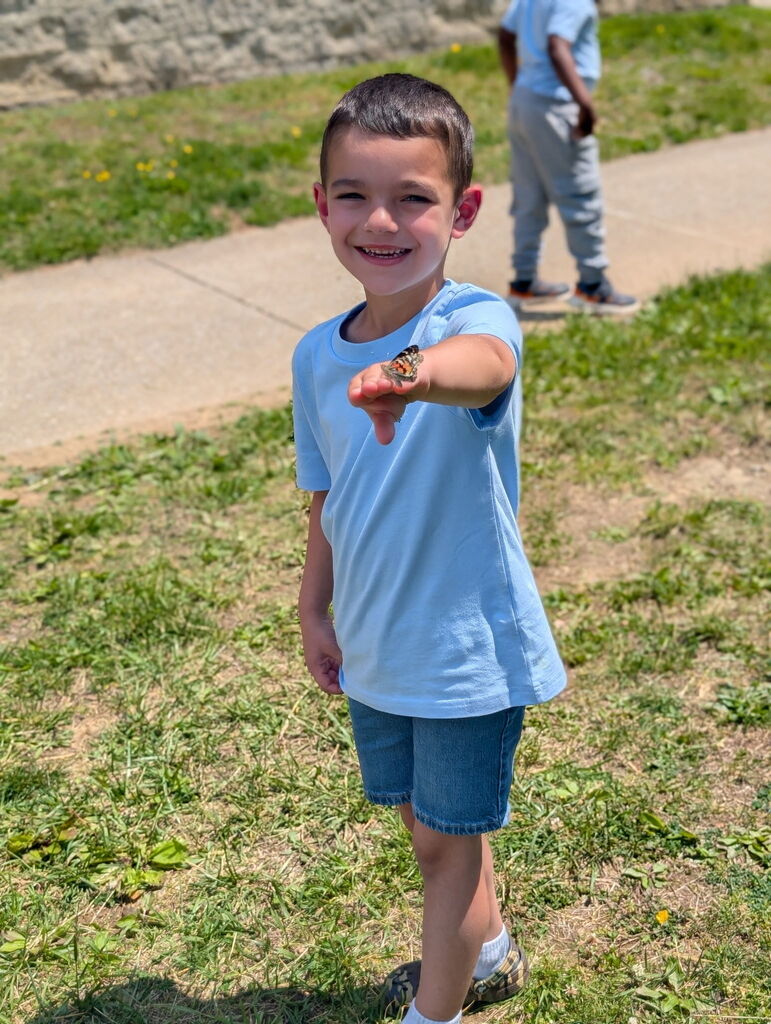Student holding a butterfly